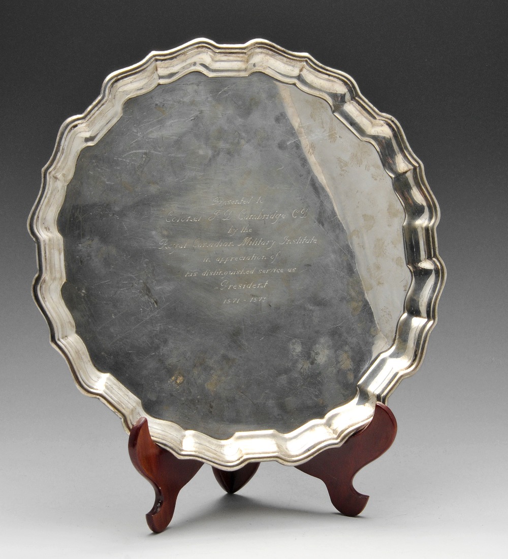 A Canadian sterling silver salver of circular form, having a scrolled rim and presentation engraving