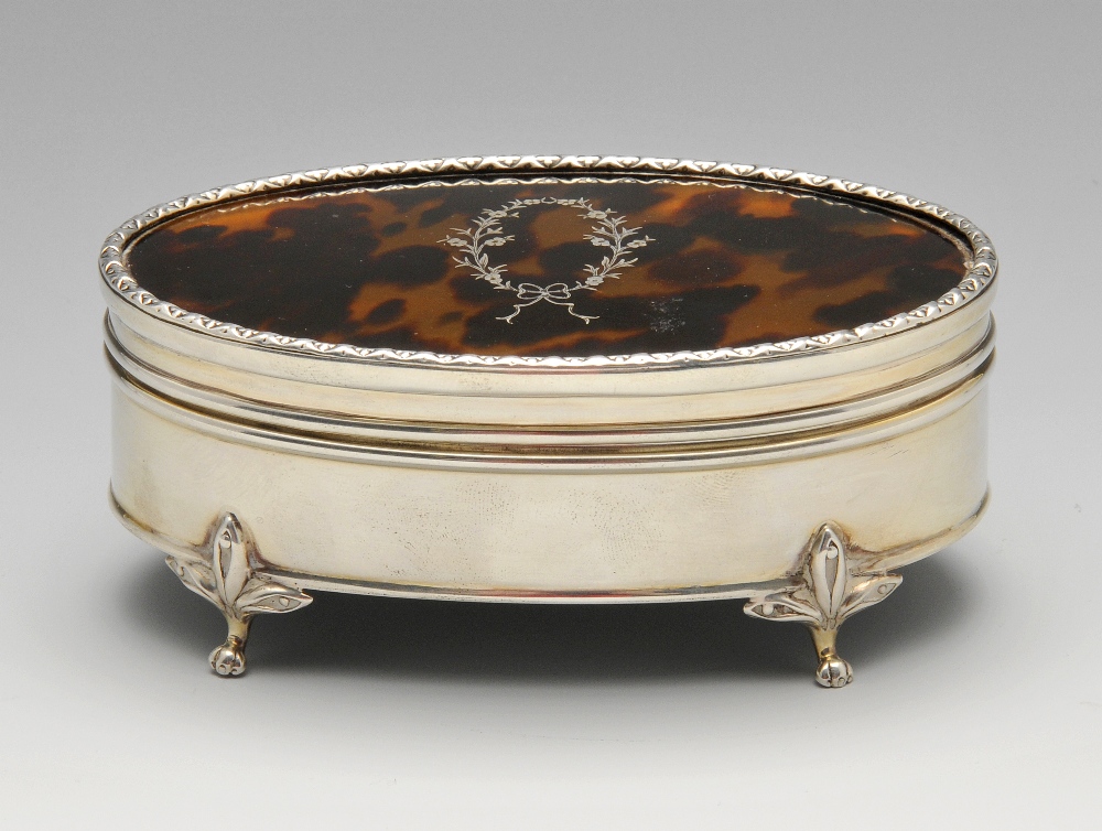 An early twentieth century silver and tortoiseshell trinket box, the oval form inlaid with a