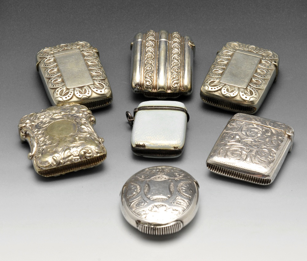 A selection of seven silver plated or base metal vesta cases to include a pair decorated with