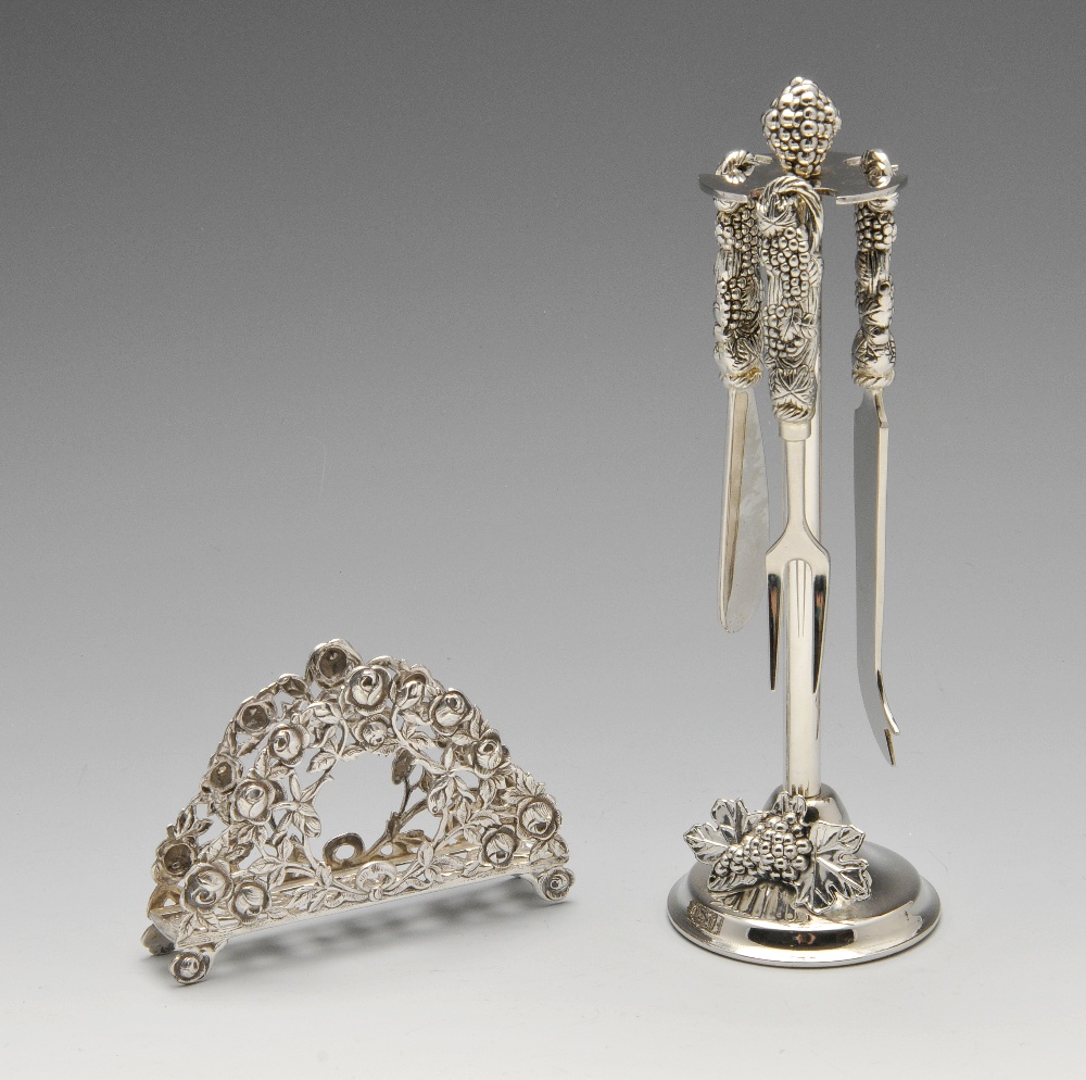 A Continental silver letter rack, of arched form pierced with roses to the whole and framing central