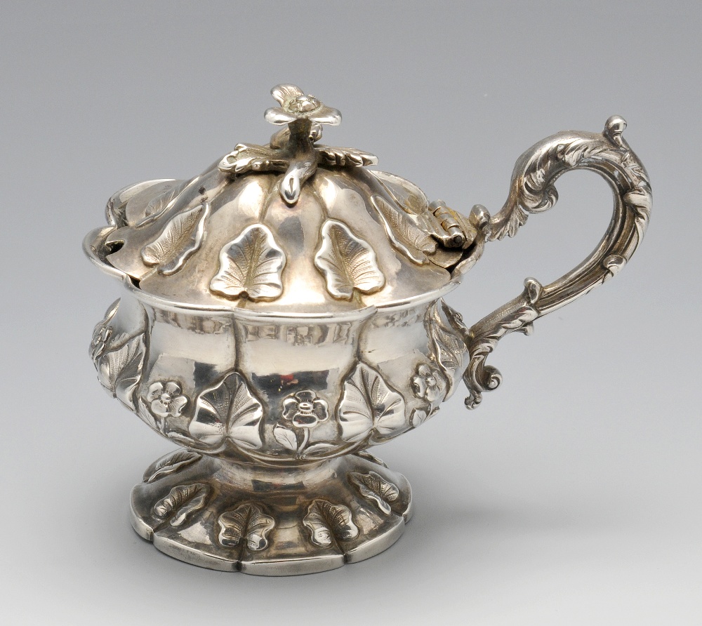 A William IV silver mustard pot of bulbous form to a footed base with petal rim, decorated