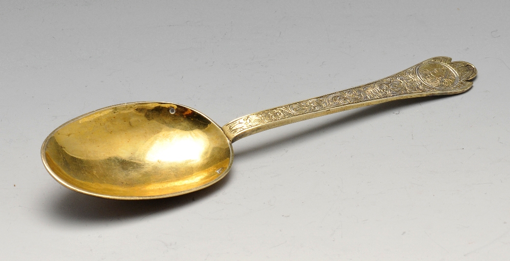 An Edwardian imported replica silver-gilt Trefid spoon with foliate engraved stem with stylised