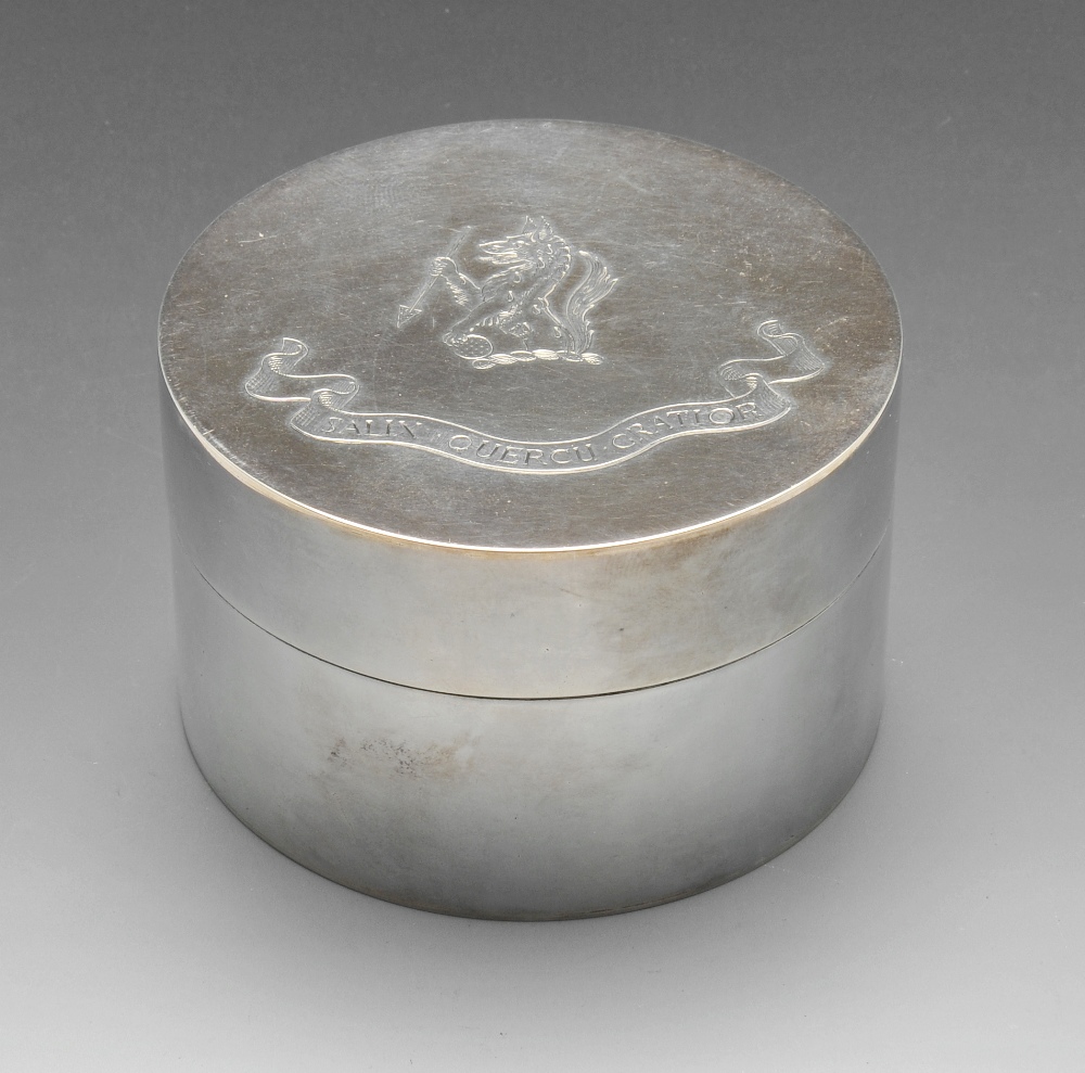 A modern silver box of circular form, the cover with crest and motto engraving and opening to a