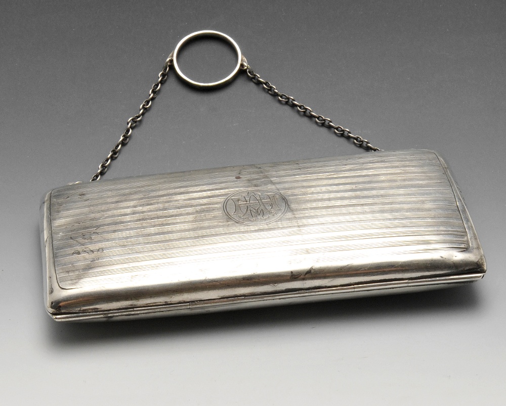 An early twentieth century silver purse or case, the oblong hinged form with reeded decoration,