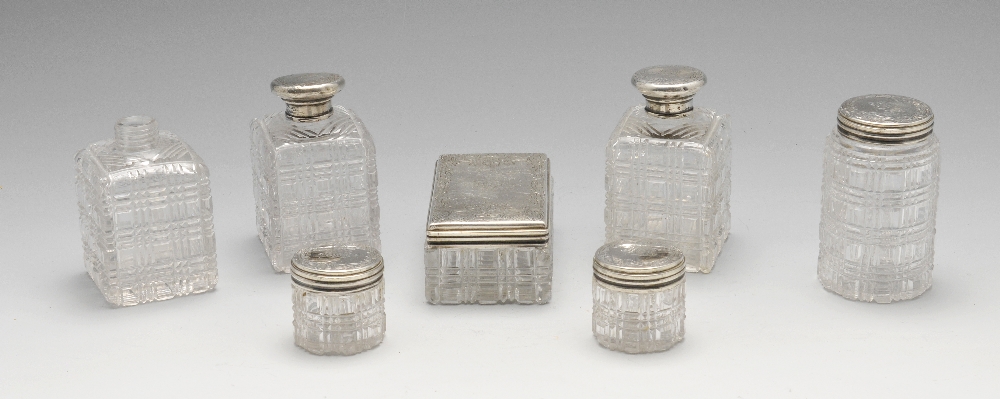 A set of seven mid-Victorian cut glass silver mounted dressing table jars, the silver covers