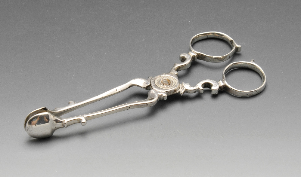 A pair of Georgian silver scissor action sugar tongs with scroll arms and loop handles. Incuse