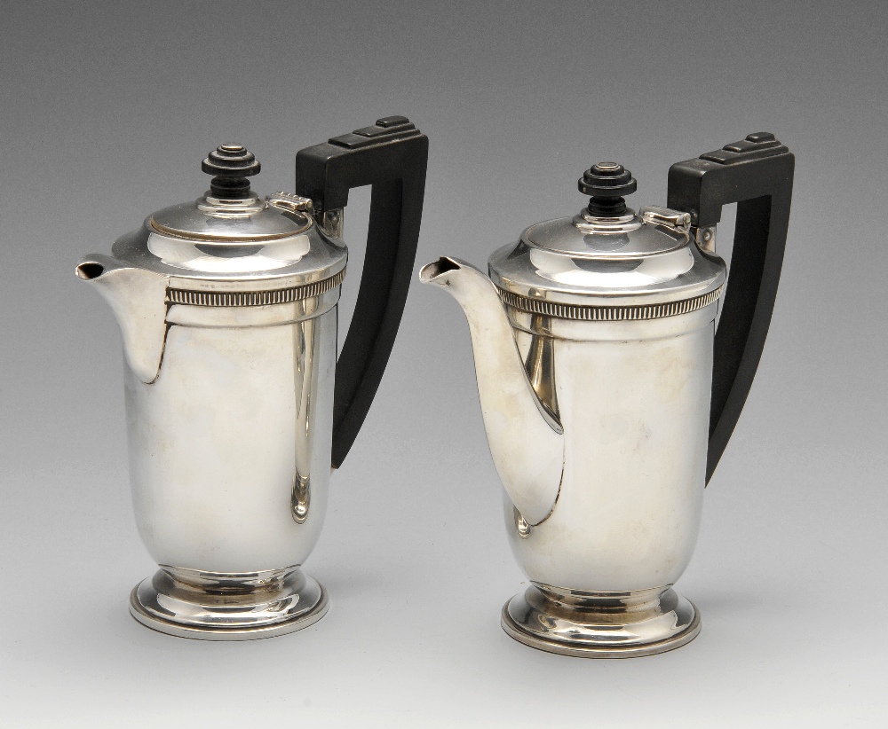 A pair of silver Art Deco cafe-au-lait pots, the plain conical form with stepped accents to the