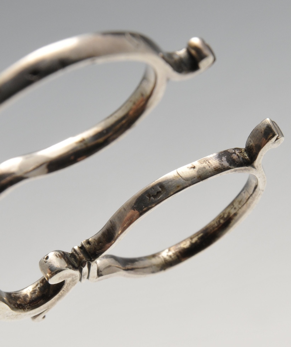 A pair of George III silver sugar tongs of scroll form, crested and with shell bowls, together - Image 4 of 8