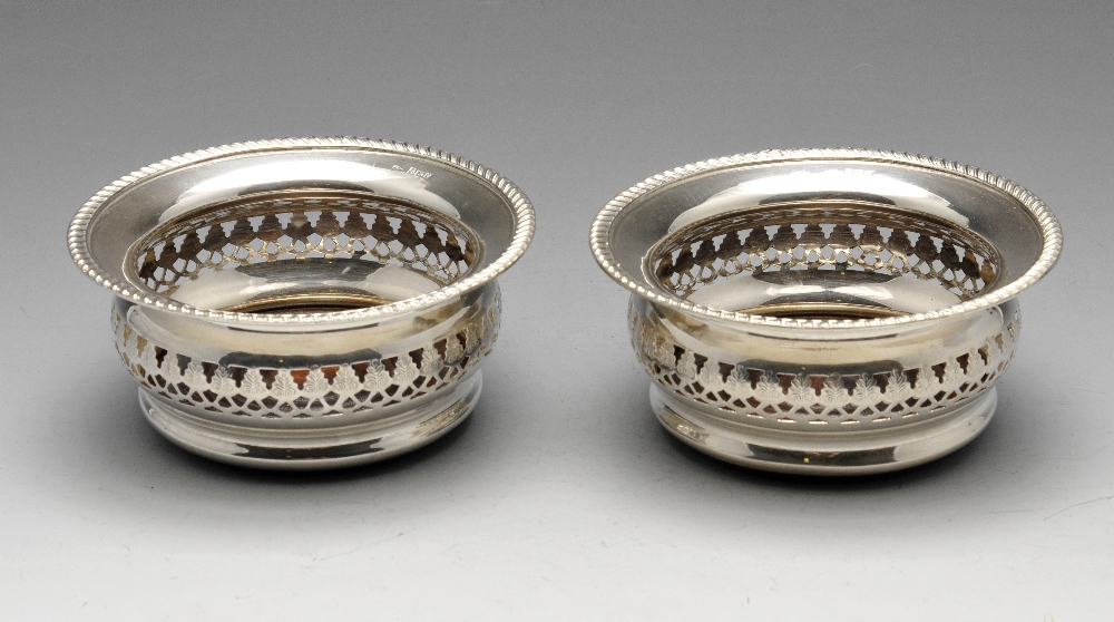 A pair of modern silver mounted bottle coasters, each of circular bulbous form with gadroon rim