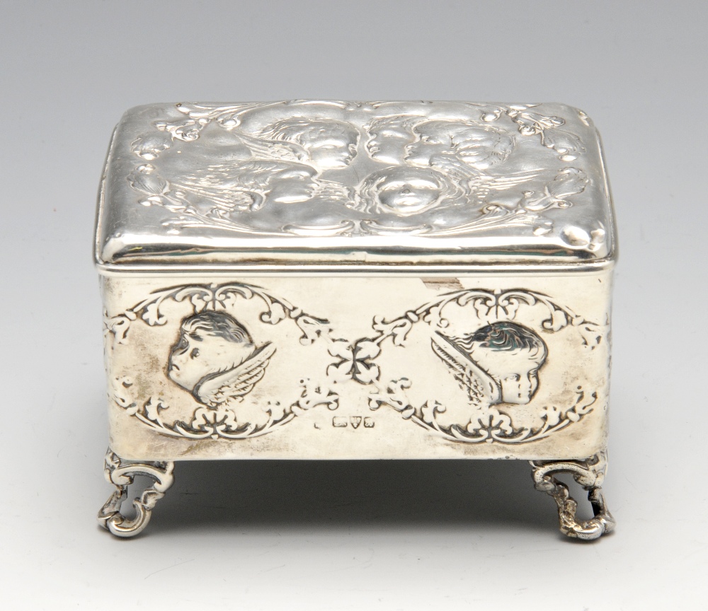 An Edwardian silver mounted jewellery box of oblong form, embossed with putti and opening to a