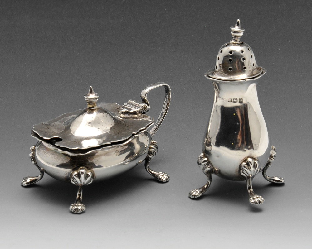 An early twentieth century silver pepper pot and a matching mustard pot with blue glass liner,