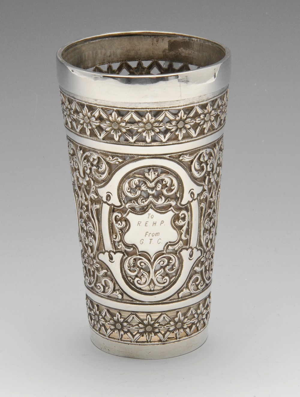 A continental Indian style beaker, the slightly tapering form ornately pierced with stylised