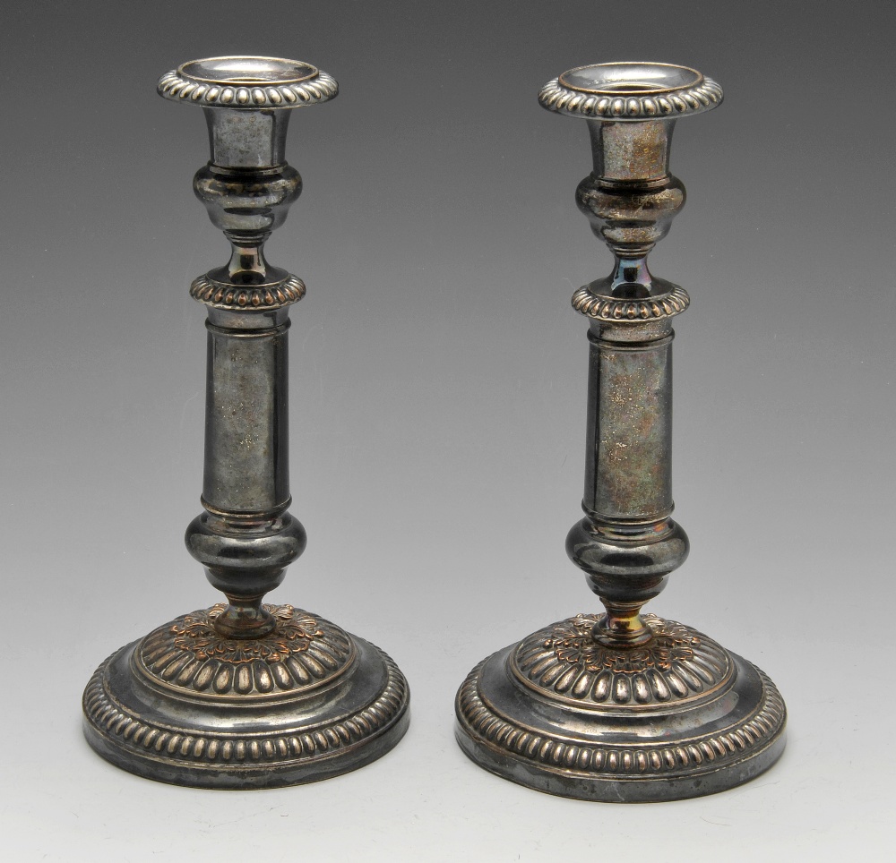 A pair of French plated candlesticks, each with circular base rising to a knopped, cylindrical
