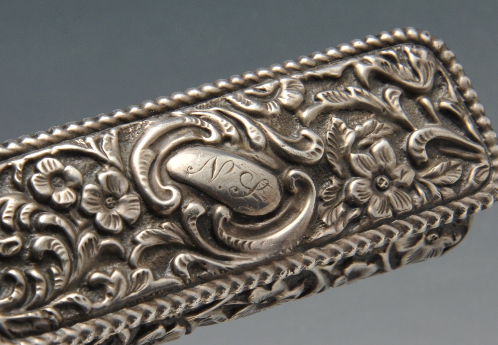 A late Victorian small silver box of oblong form, ornately embossed with floral and foliate - Image 4 of 8