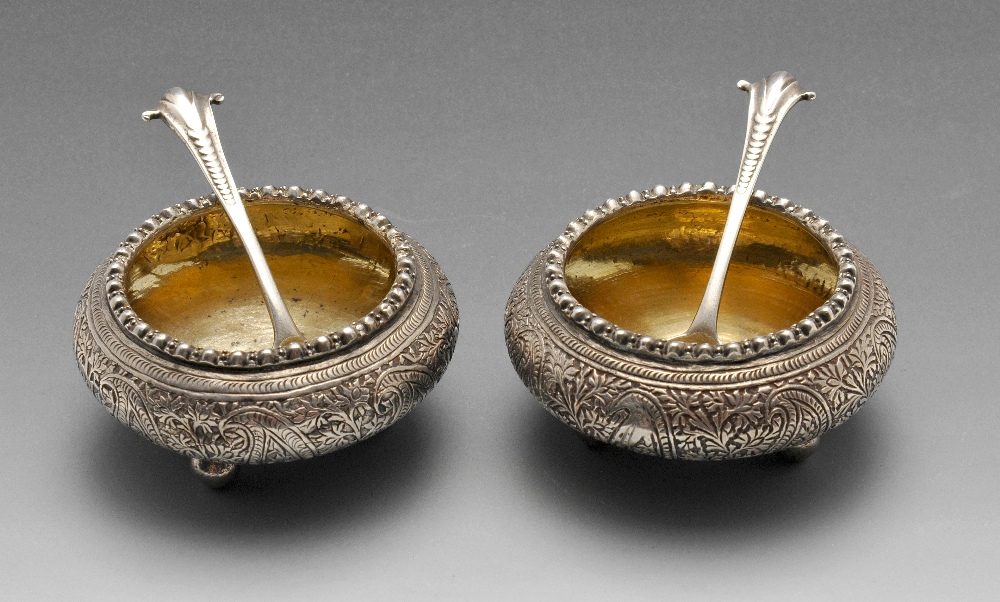 A pair of Eastern white metal open salts, of squat cauldron form having frilled rim above a