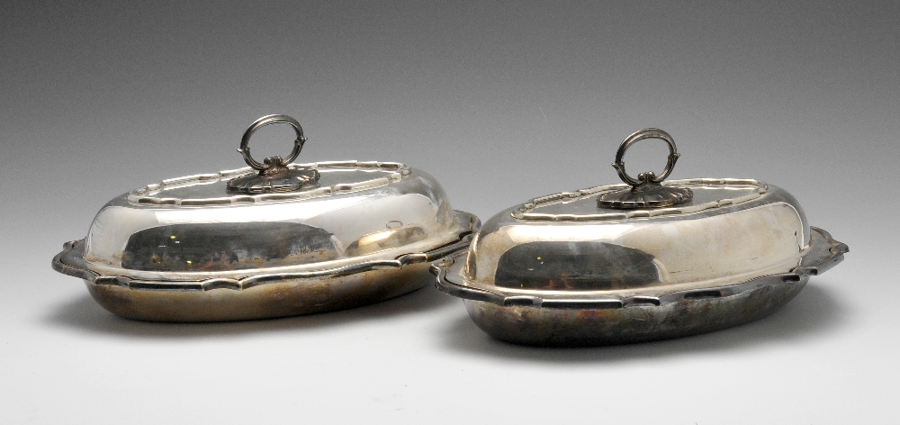 A pair of silver plated entree dishes of oval form with a Chippendale style rim, maker's mark for