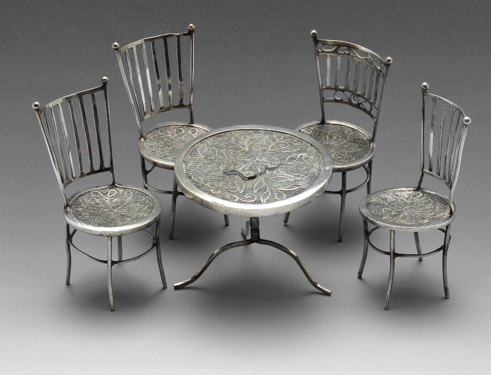 A toy or miniature table and chairs set, comprising circular table raised upon tri-form base, and