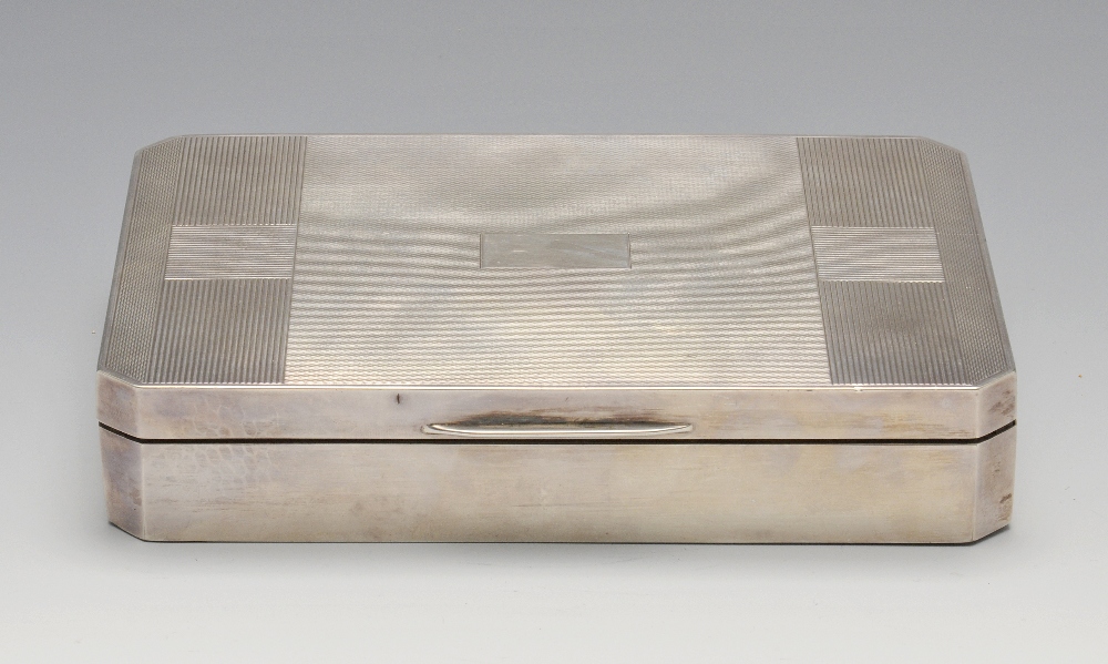 A 1940's silver mounted table cigarette box, of rectangular form with canted corners having engine-