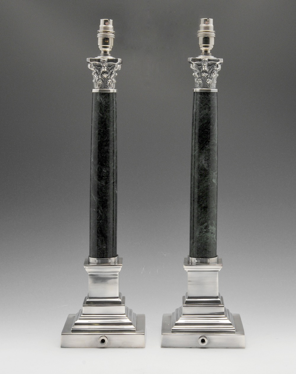 A pair of modern silver plated table lamp bases, each with an acanthus leaf moulded capital above