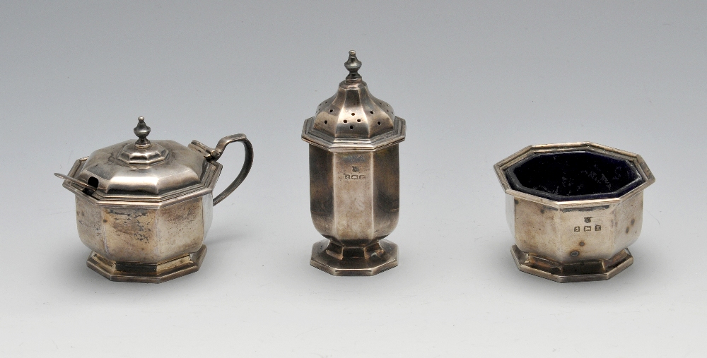 A 1920's three-piece silver condiment set comprising open and covered salt with spoon and blue glass