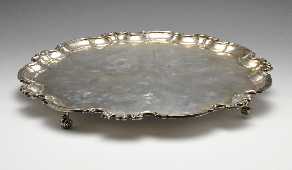 An early twentieth century large silver salver of circular form, the raised scalloped edge