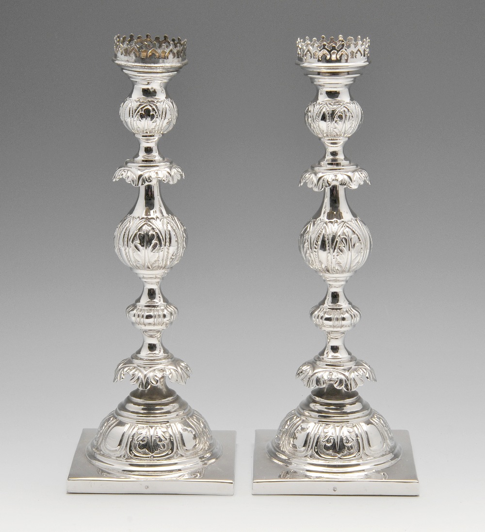 A pair of Russian silver candlesticks, each with a weighted square base rising to a bulbous