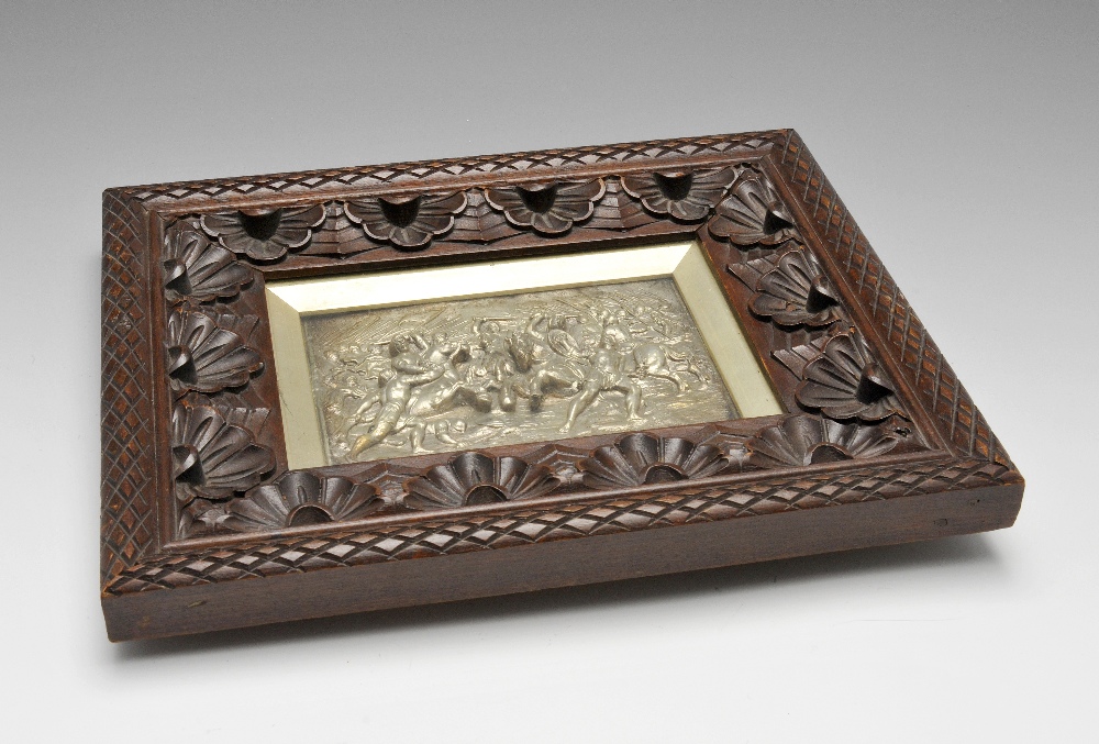 An Elkington style silver plated wall plaque, depicting in high relief a battle scene. In wooden