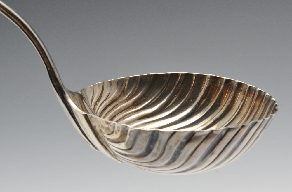 An early George III silver soup ladle with shell and scroll terminal and crest engraving to the - Image 4 of 6