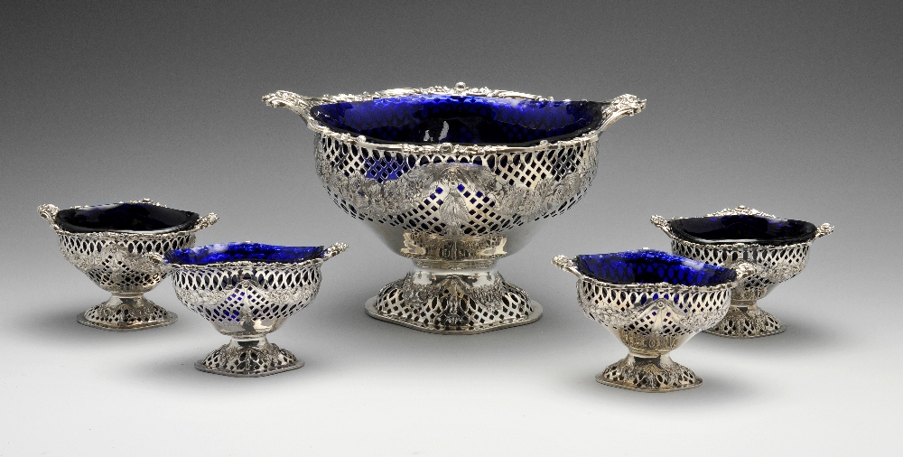 A late Victorian silver matched set of five pierced dishes with blue glass liners, comprising one