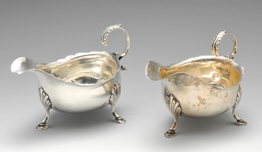 A matched pair of George V silver sauce boats, each having shaped rim above bulging body and with