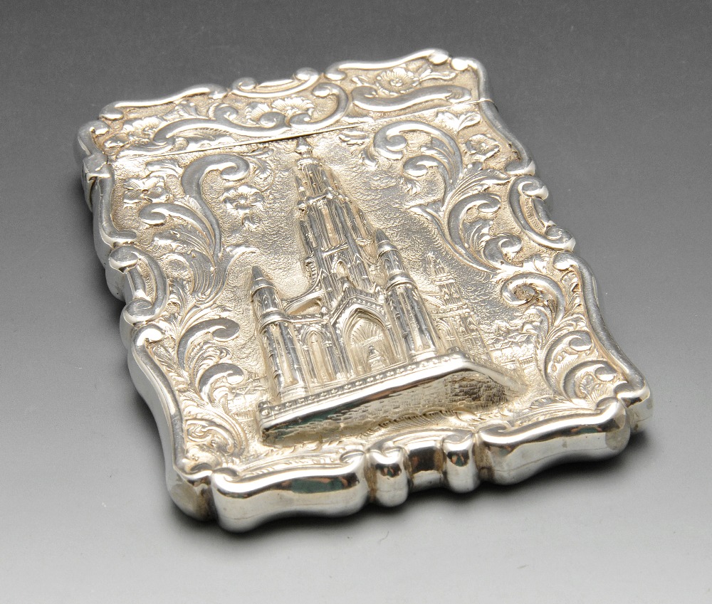 A Victorian silver castletop card case depicting the Scott Memorial within floral scroll surround.