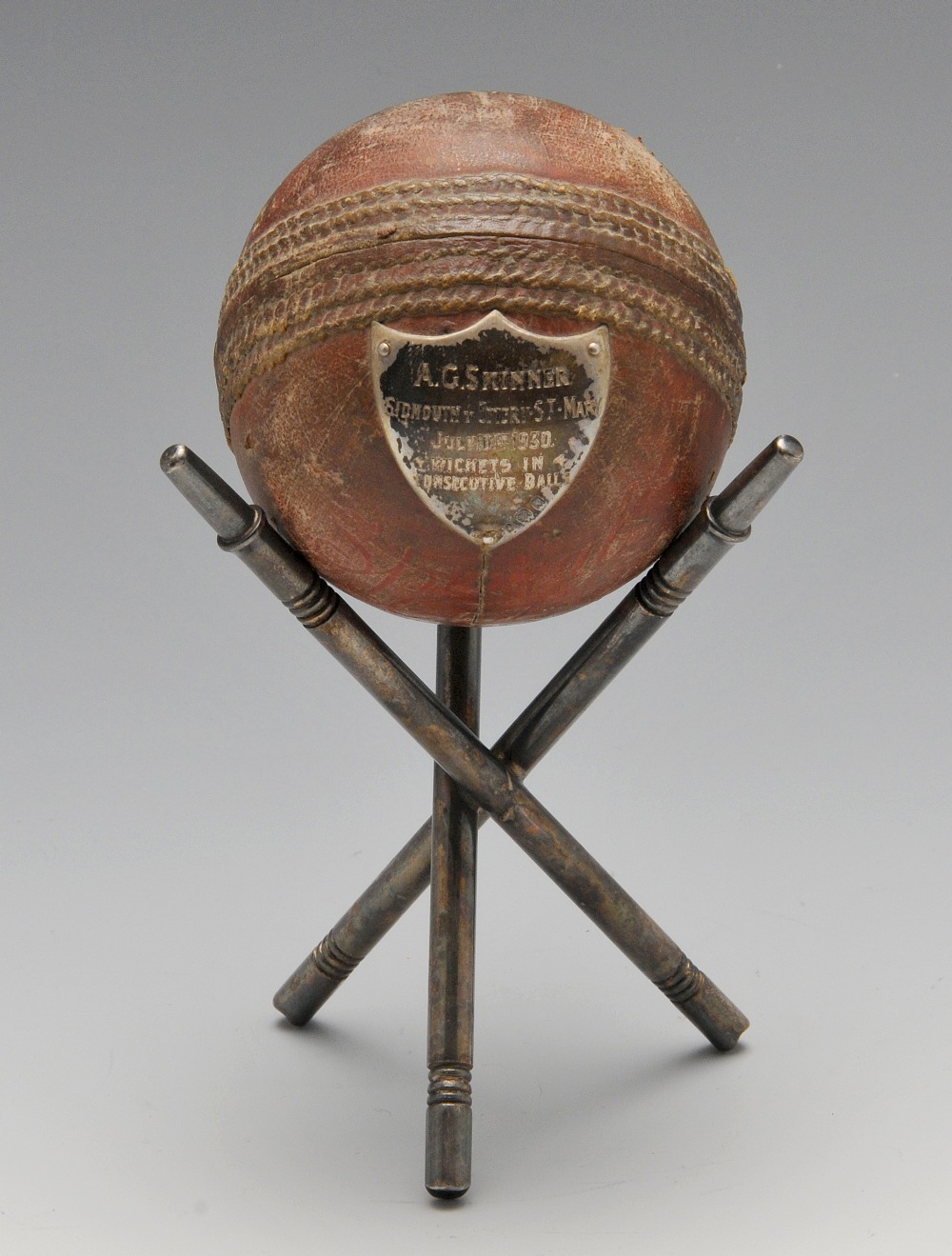 A 1930's silver mounted cricket ball raised upon tri-form stand. Hallmarked London 1930.