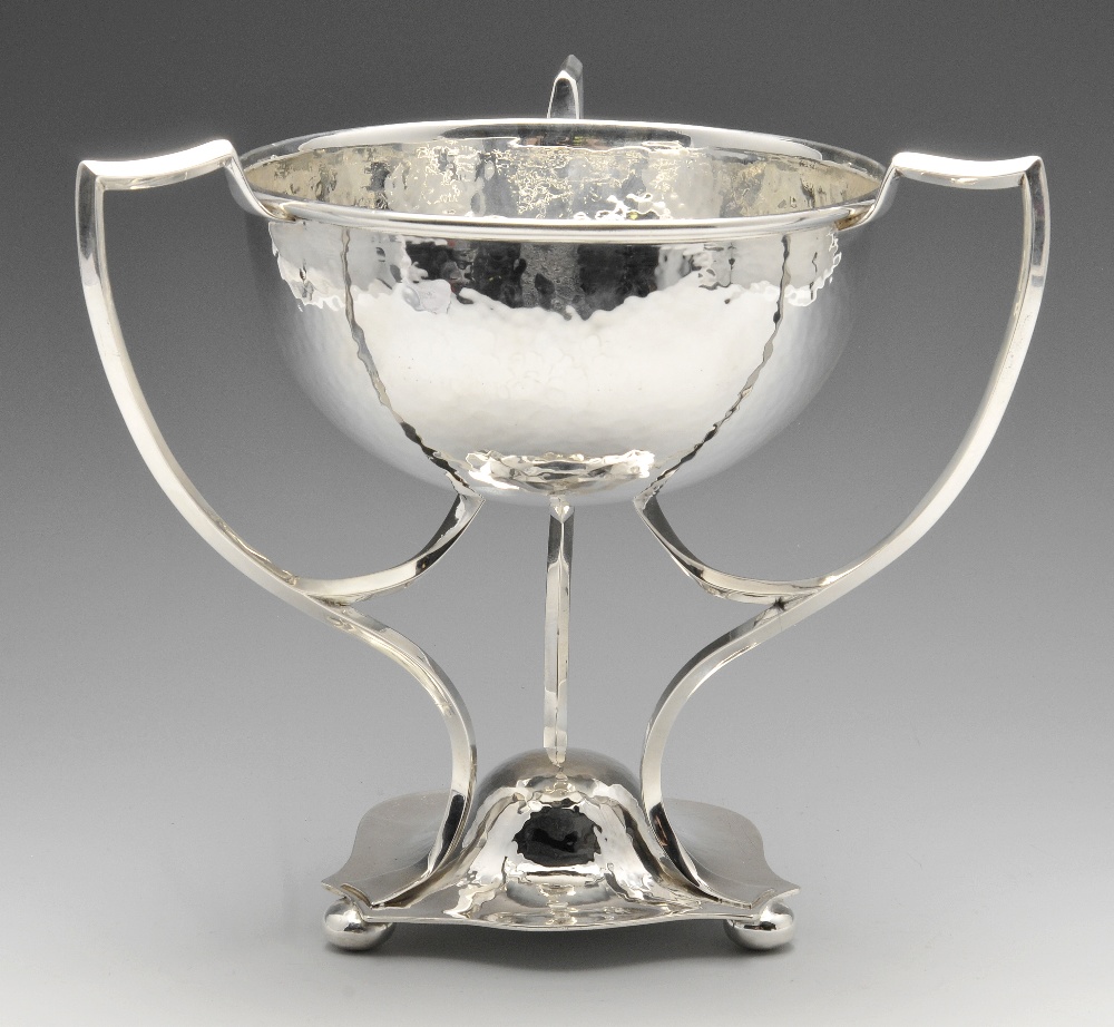 An Arts and Crafts silver cup, the hemispherical bowl with planished finish, raised on three