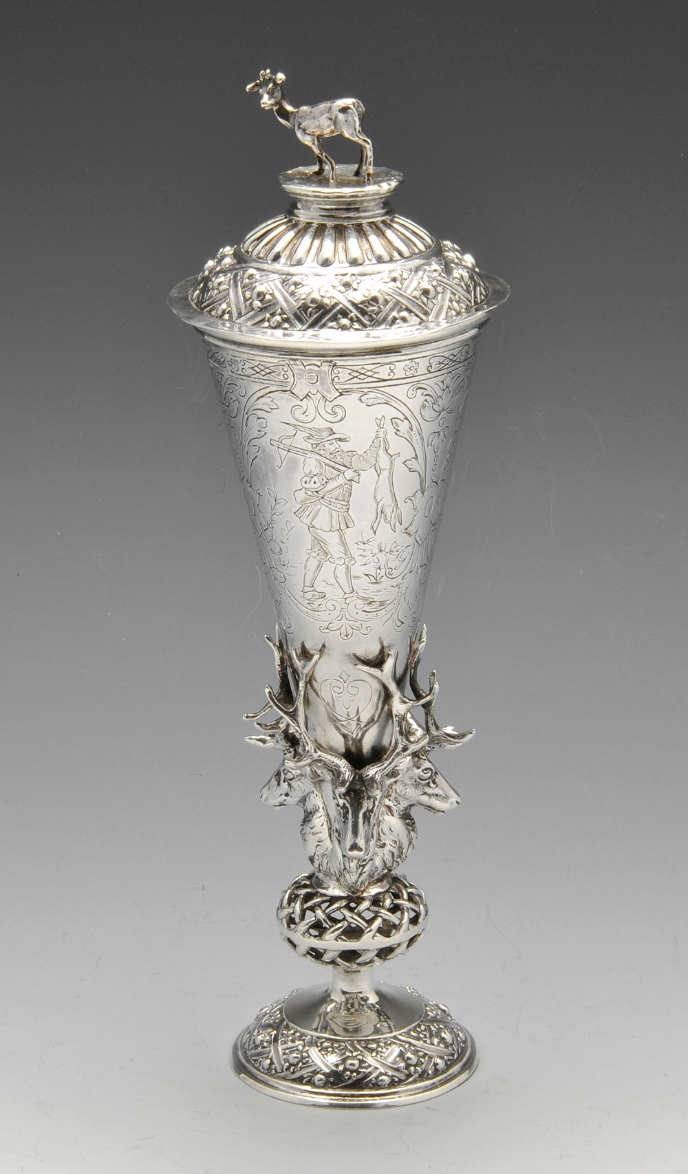 A late nineteenth century imported silver hunting cup and cover, the conical body engraved with