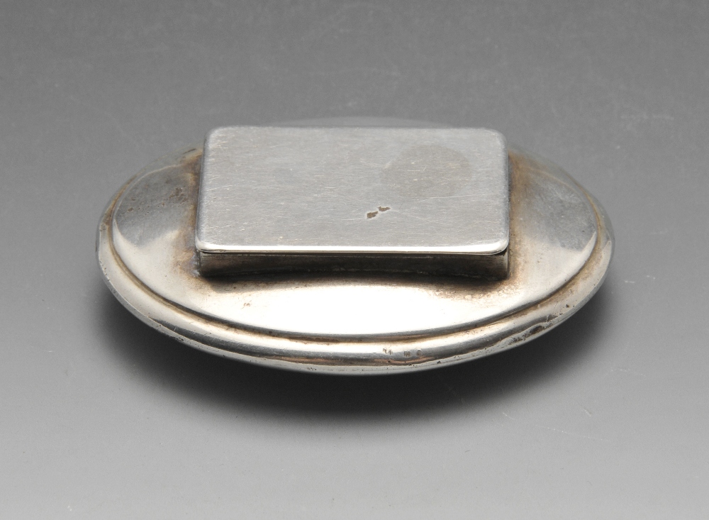 A George III silver snuff box of oval form with oblong hinged opening and applied vacant