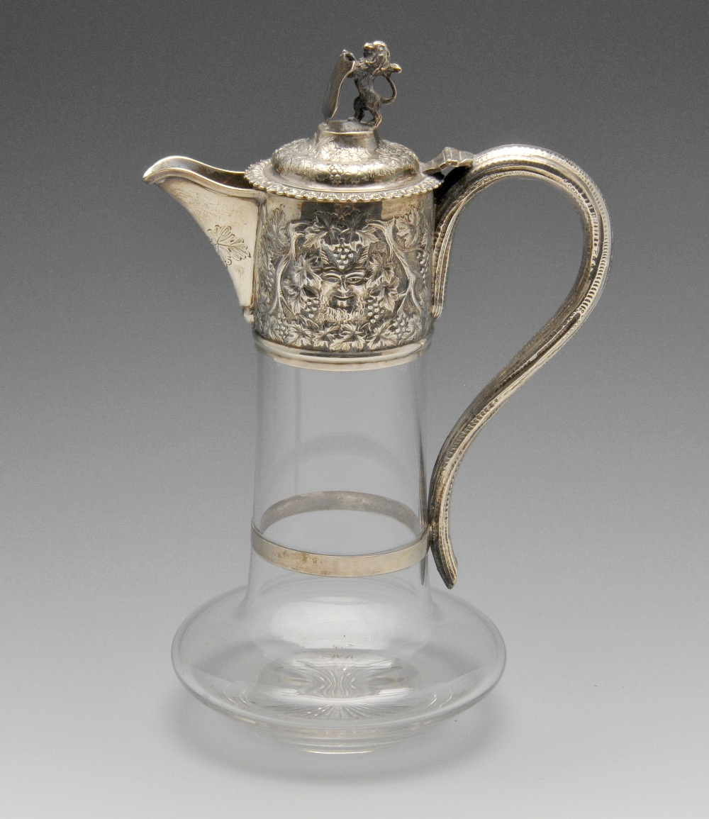 A late Victorian silver mounted claret jug, the Bacchanalian mount having lion and vacant shield