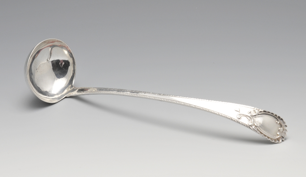 An early George III silver toddy ladle with feather edge and vacant scrolled cartouche to