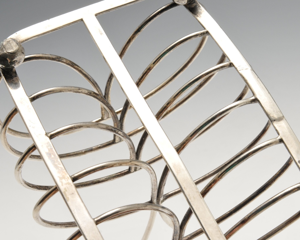 A George IV six-divide silver toast rack, the kidney wirework frame on oblong base and raised on - Image 3 of 3