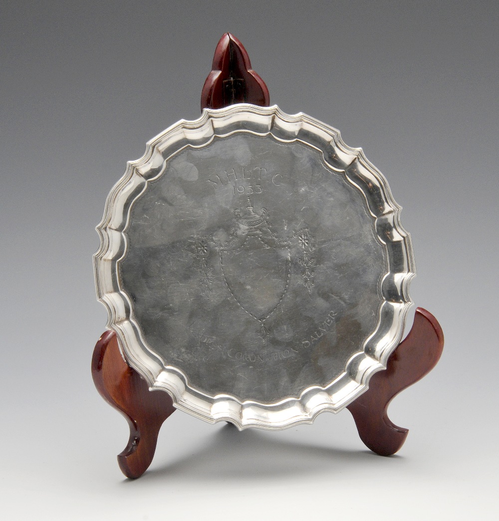 An Edwardian silver salver, the circular body with Chippendale style border, reeded rim,