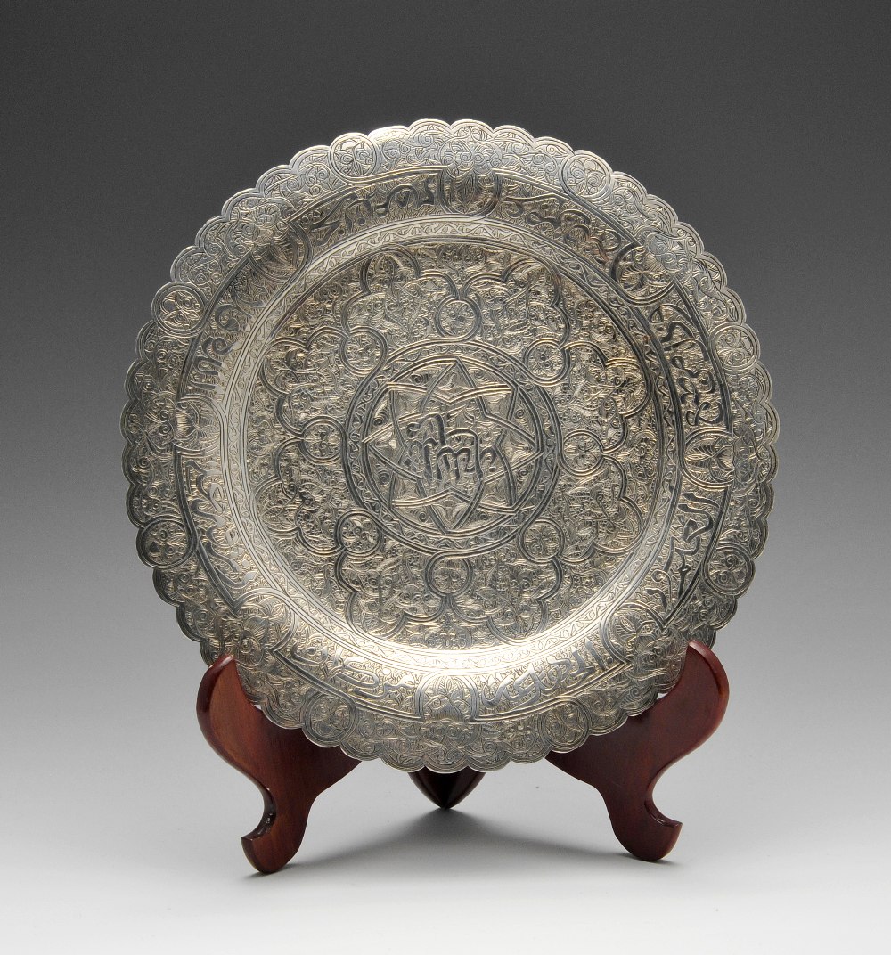 An Egyptian silver plate, the circular form entirely close engraved with intertwining motifs, raised