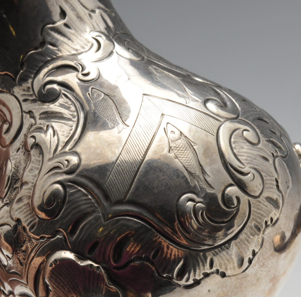 A George II silver cream jug of bulbous form with floral embossing surrounding an engraved crest, - Image 4 of 4