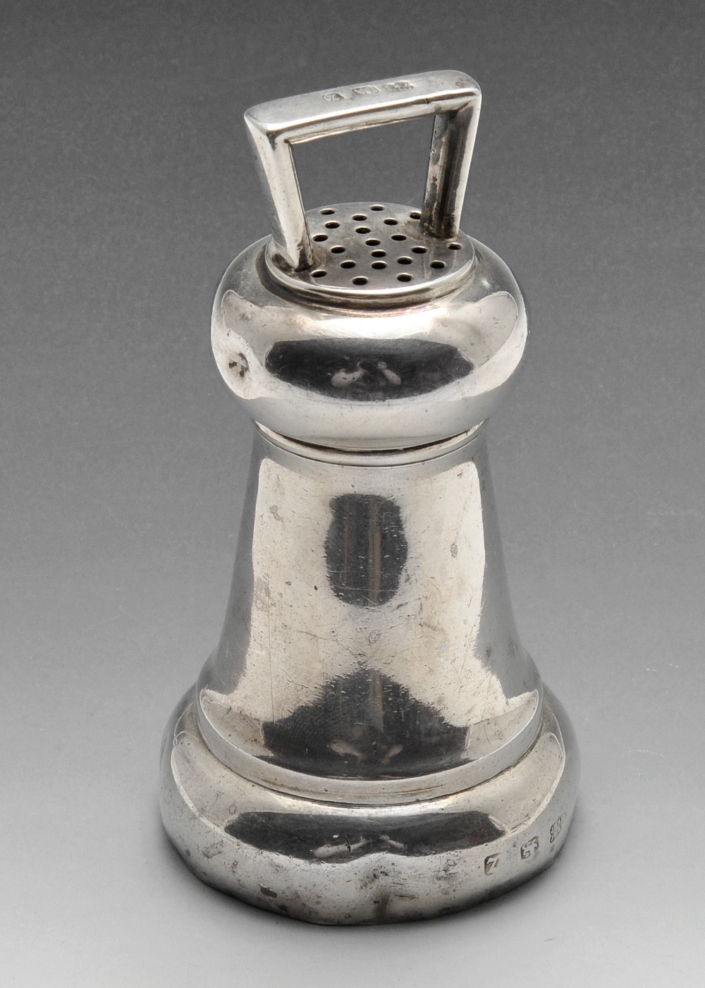 A late Victorian silver pepper grinder modelled in the form of a bell with angular handle