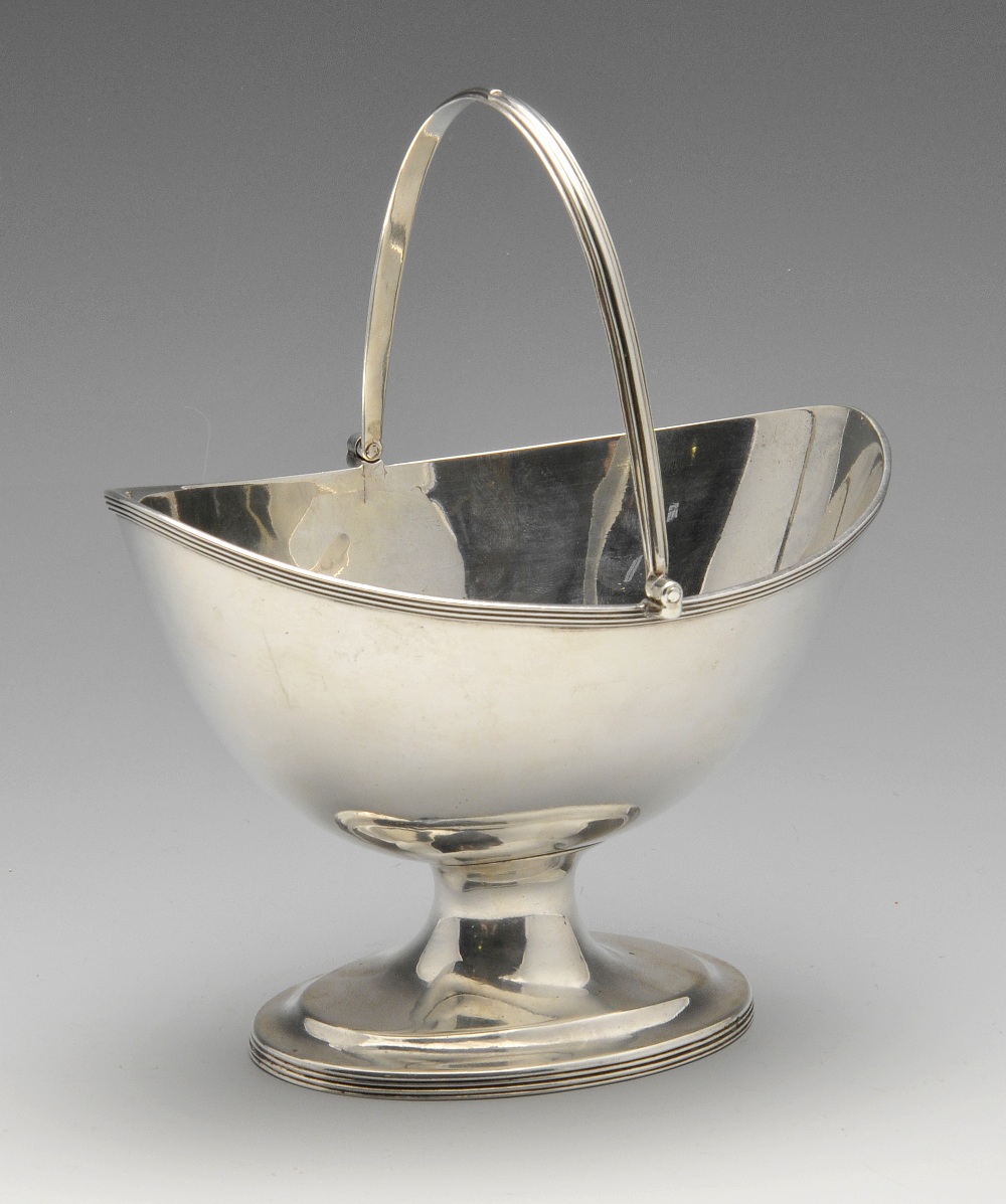 A George III silver swing handle basket, the oval pedestal form having simple reed borders.