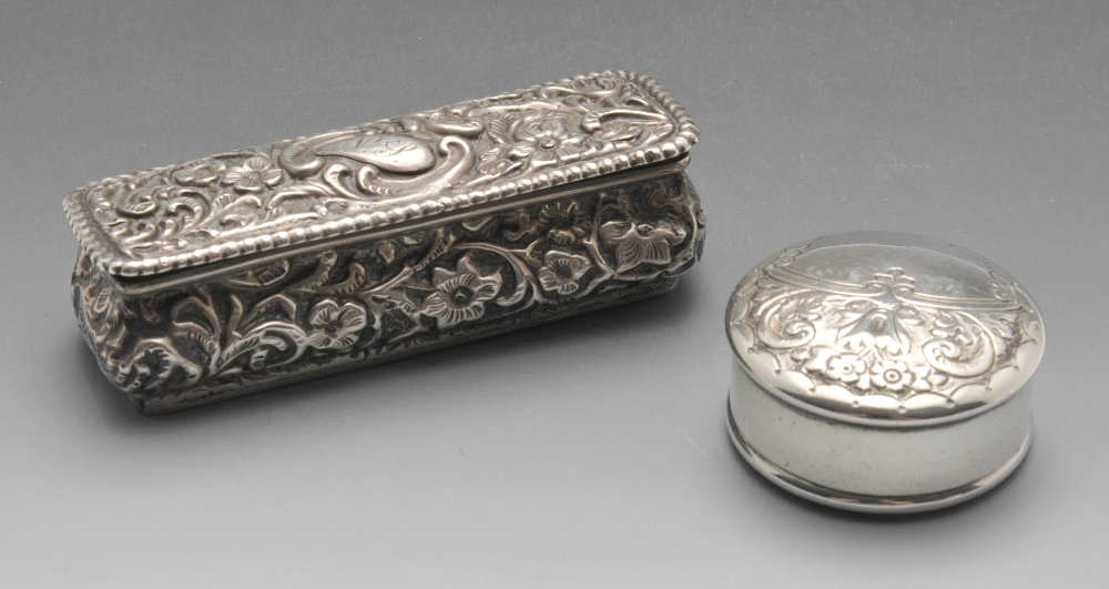 A late Victorian small silver box of oblong form, ornately embossed with floral and foliate