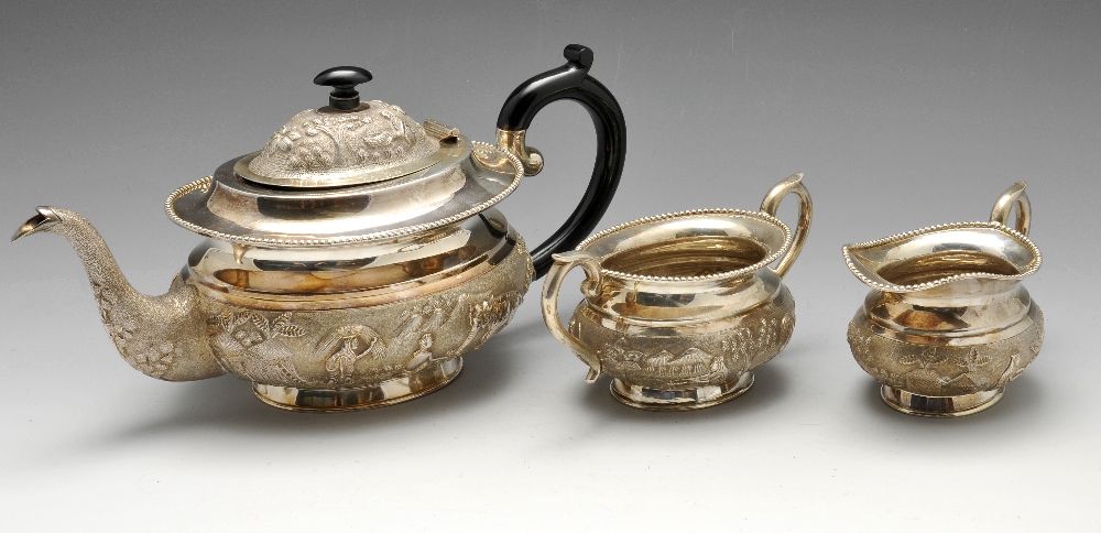 An Indian three piece tea service, complete with strainer, tongs and dish, the tea service