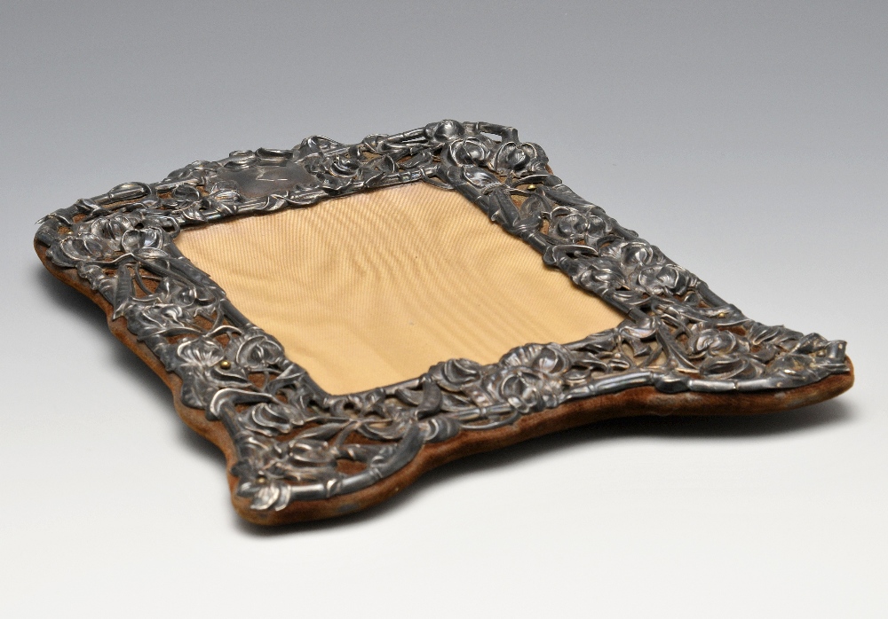 An Edwardian Art Nouveau silver mounted photograph frame, the shaped rectangular form with