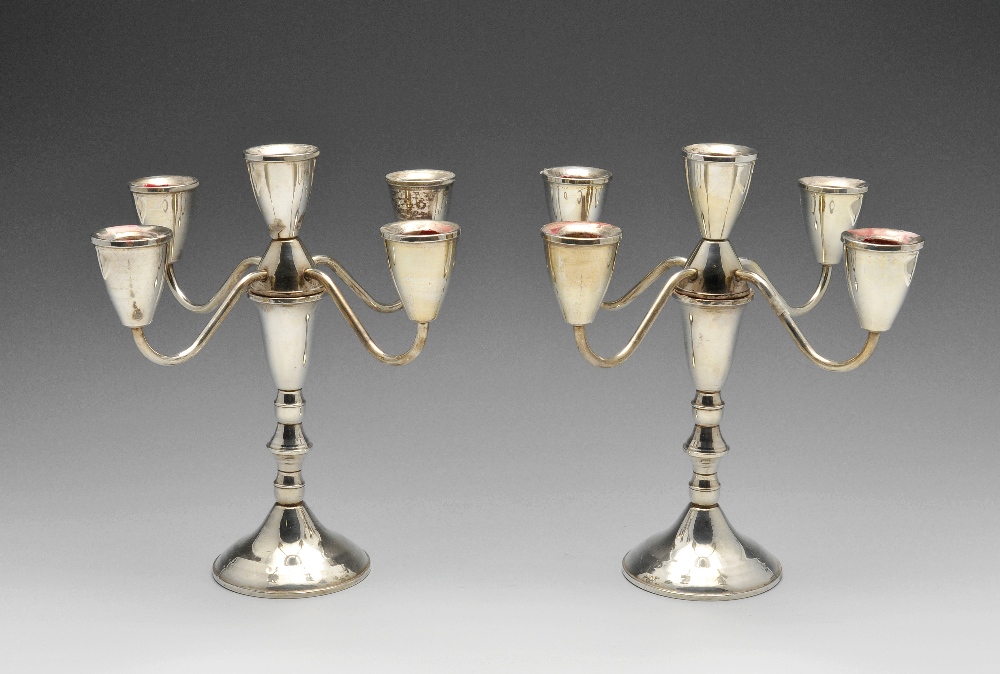 A pair of American mid-twentieth century four branch candelabra, each with circular filled base