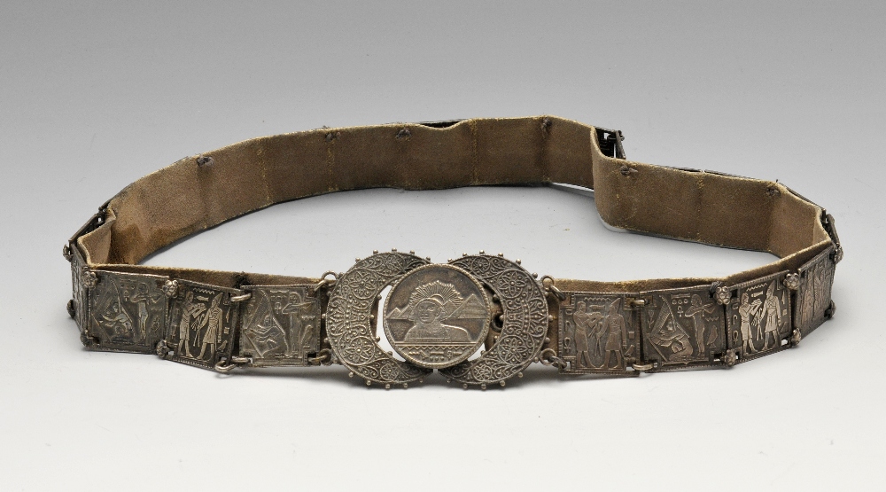 A white metal Egyptianesque belt, formed as twenty-two square links with stylised figural scenes.