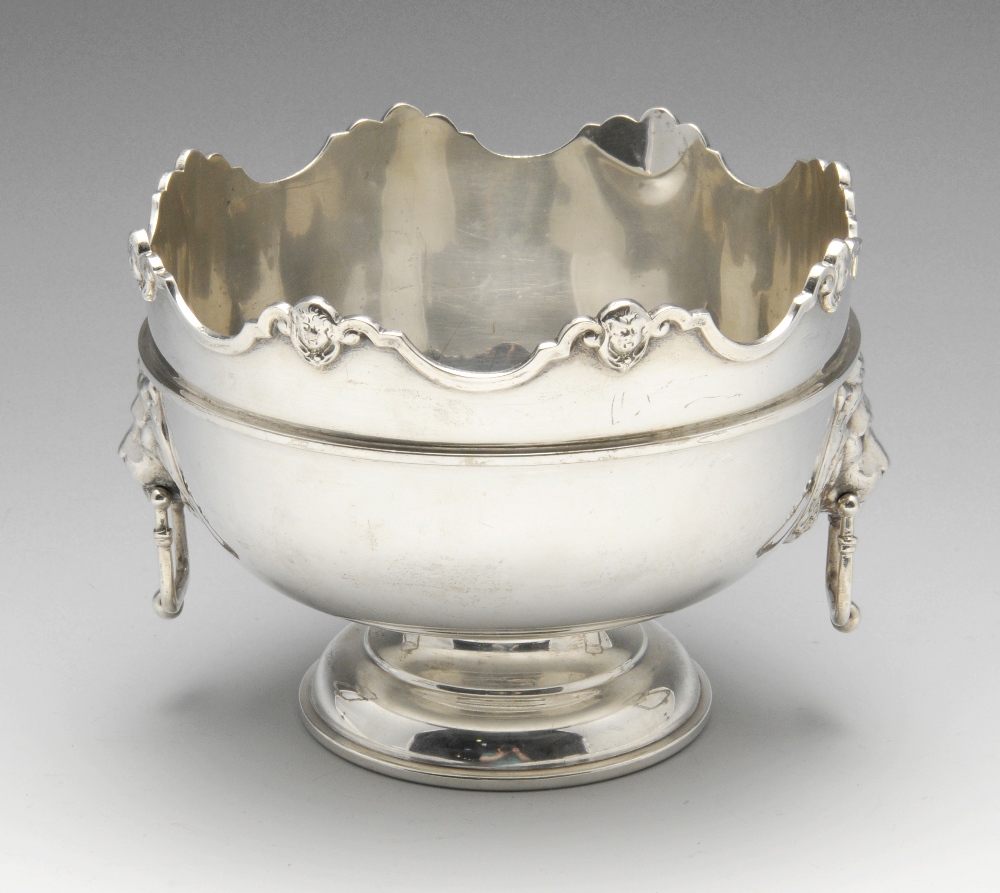 A 1920's silver rose bowl of circular form to a footed base, having an applied scroll rim