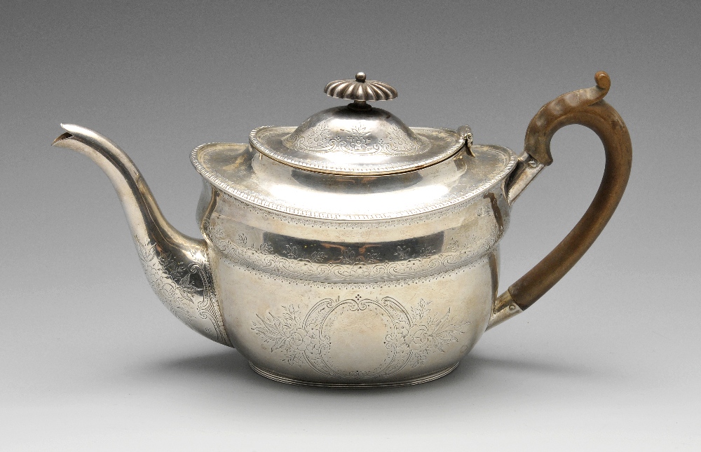 A Victorian silver teapot of oval form, the shaped body embellished with bright-cut floral scroll